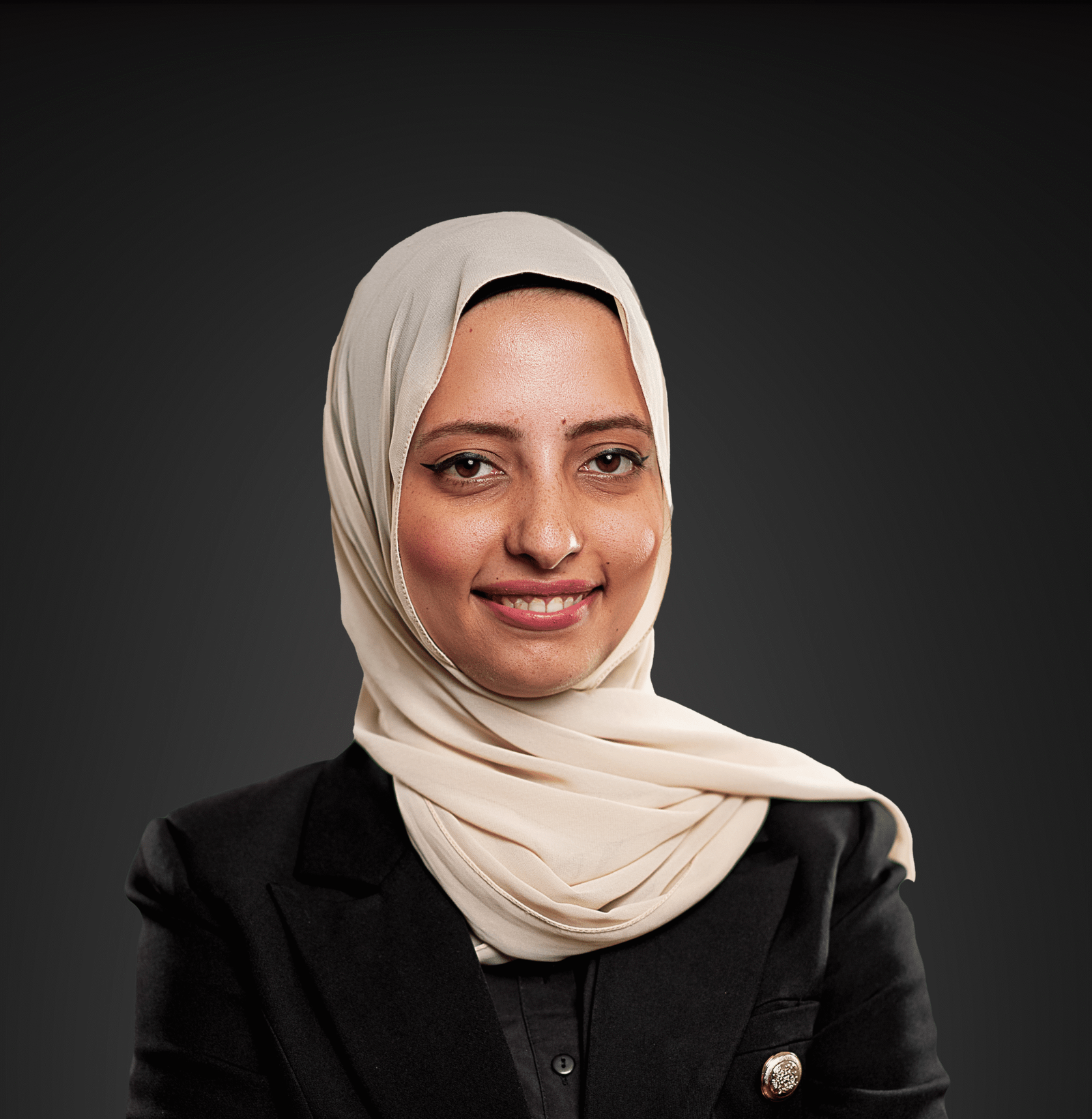 a short woman dressed in a black top and a white hojab looking at the camera